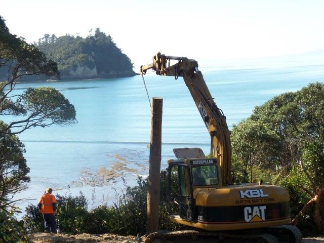 14-tonne excavator – drilling and lifting poles for barrier wall, Hatfields Beach